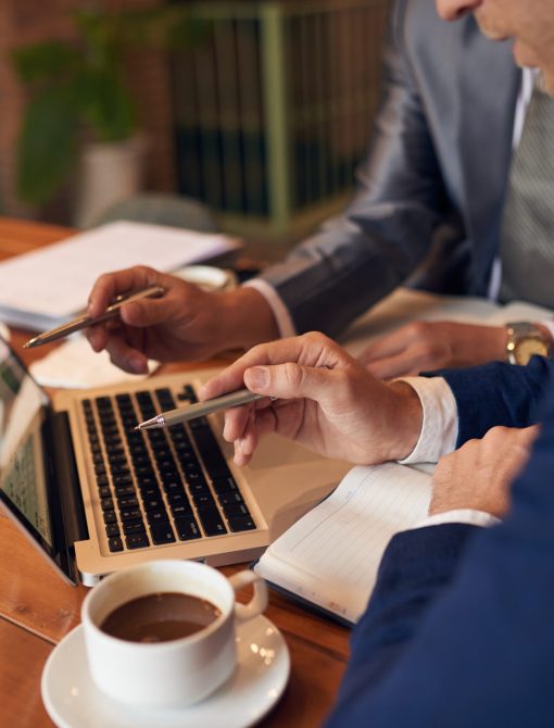 Business people analyzing statistics on laptop screen, selective focus